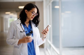 Physician checking a text message about a patient on a smartphone