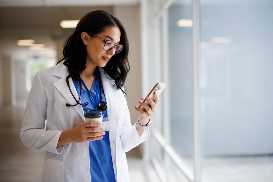 Physician checking a text message about a patient on a smartphone
